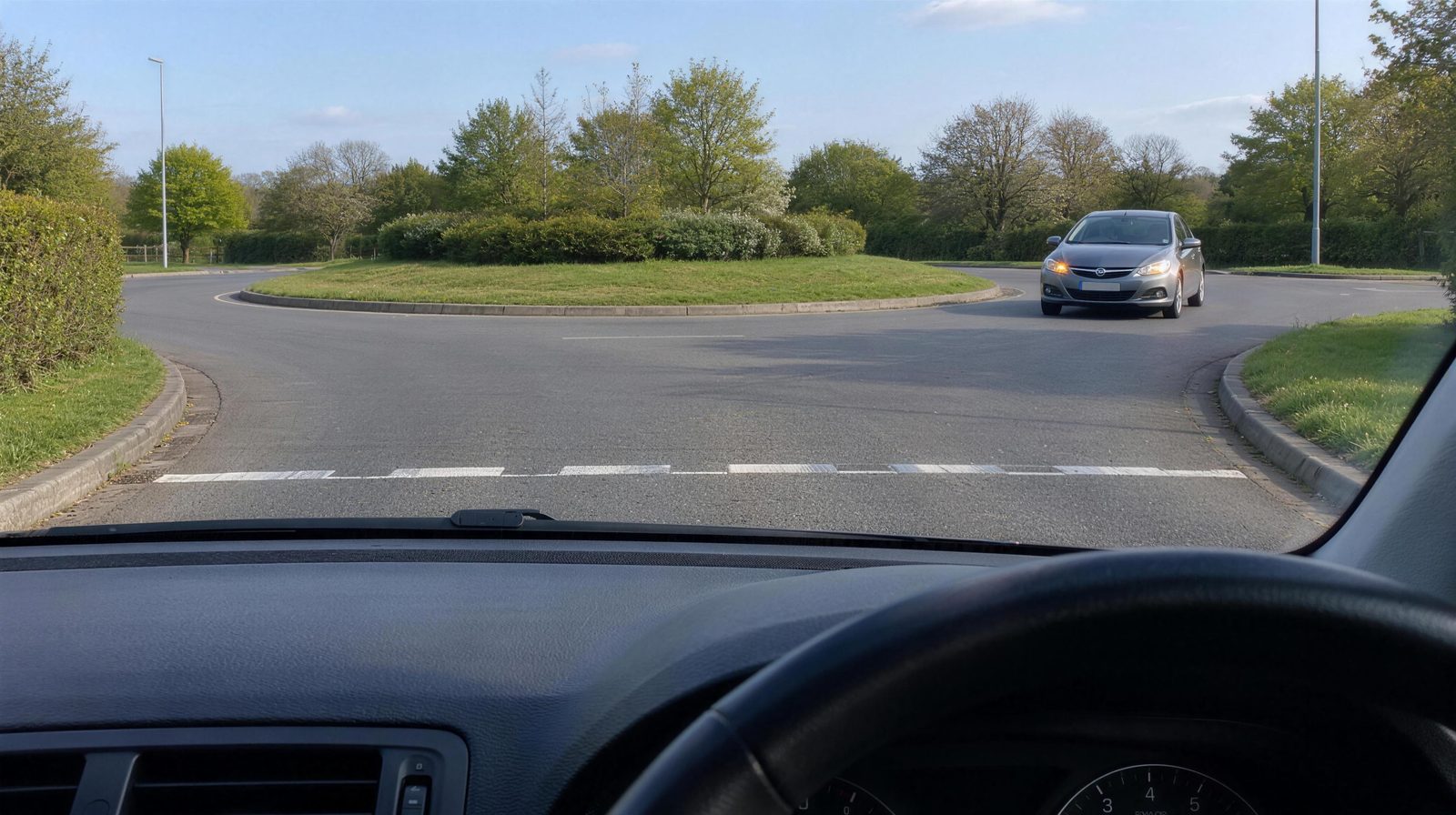 At the give way line of a roundabout, with a car coming round from the right, its right indicator flashing